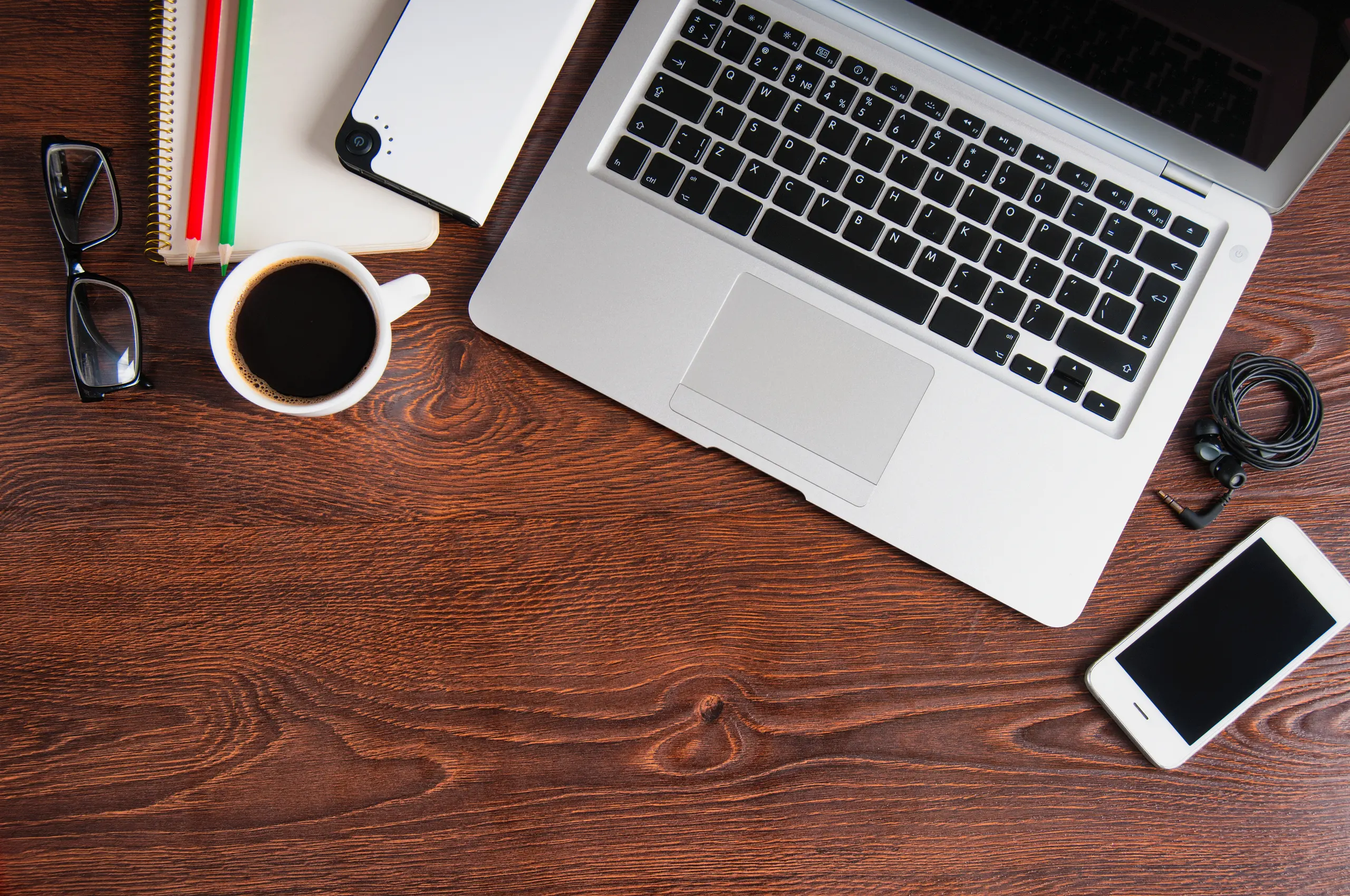Notebook with hot coffee on a wooden table