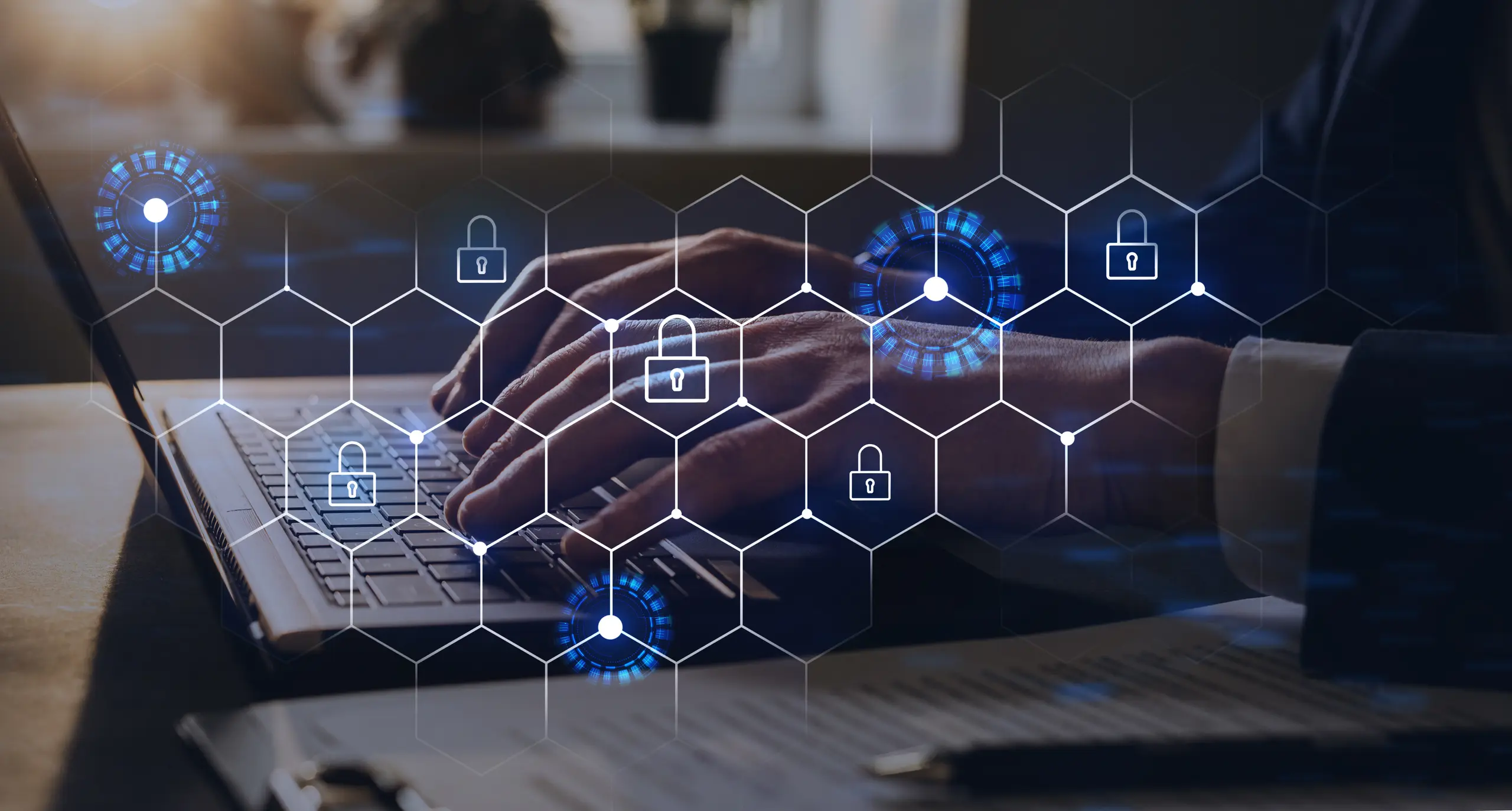 Padlock on a hex grid background with person typing on a laptop