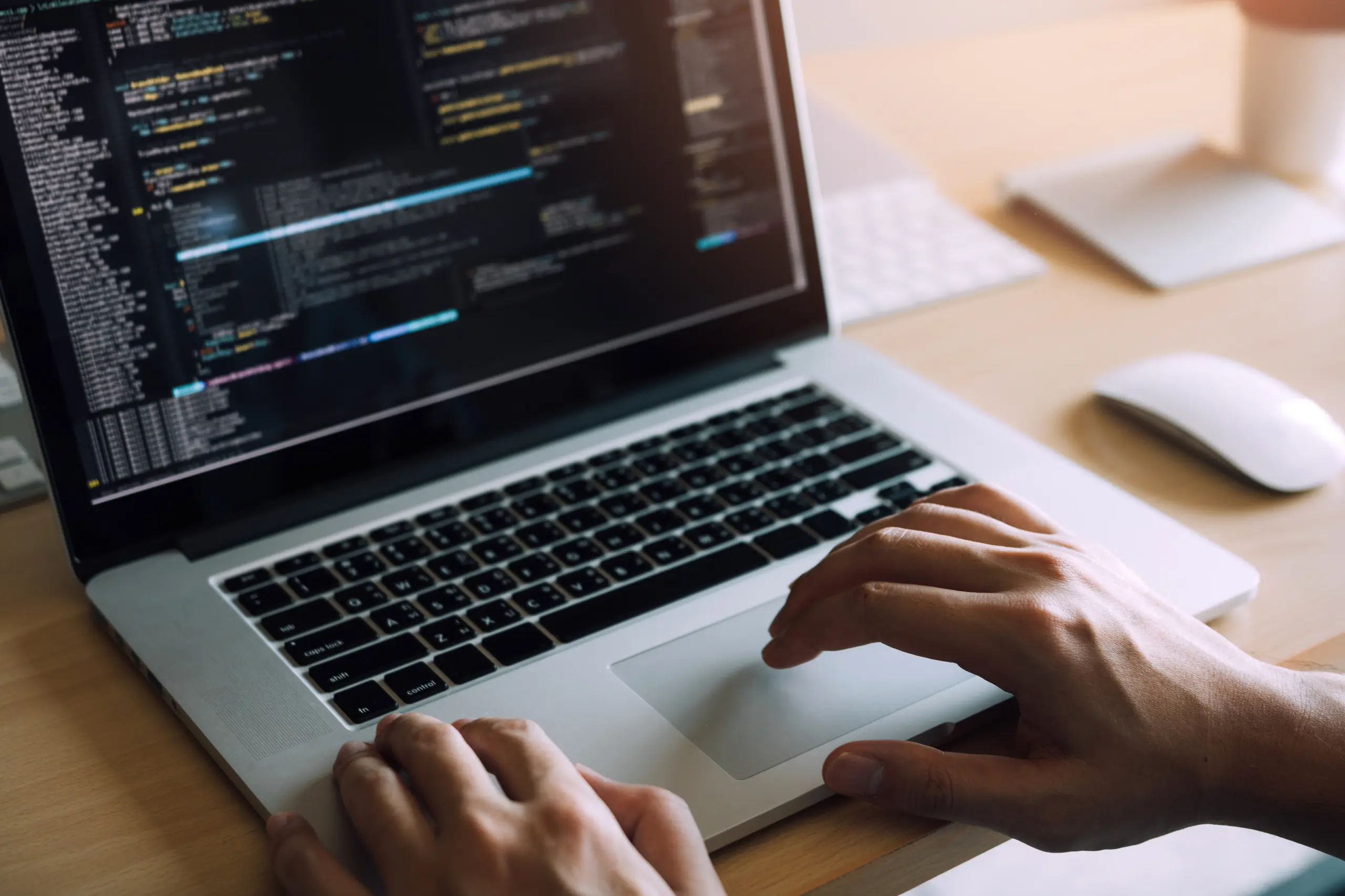 Person moving the cursor on a laptop showing code
