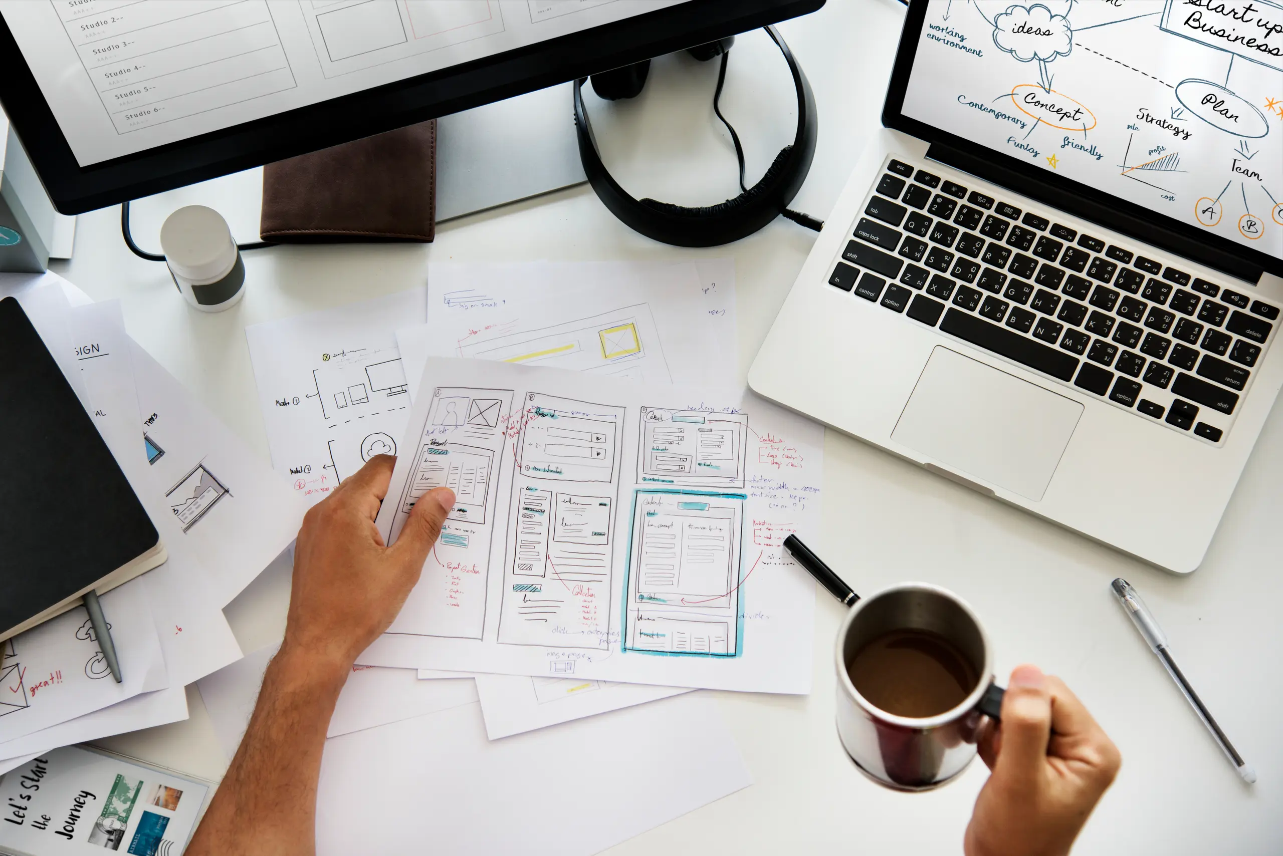 Person holding coffee while working on UI/UX design