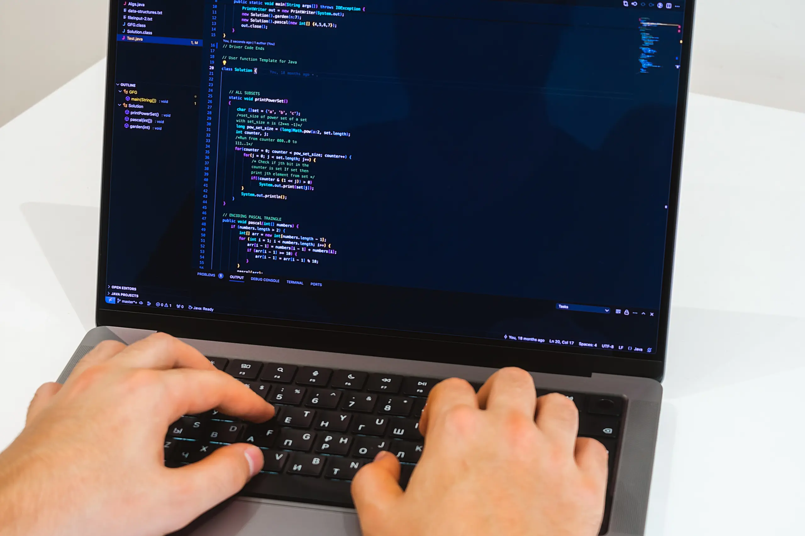 Person typing code on a laptop, front view